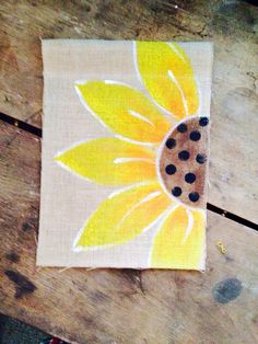 a piece of fabric with a sunflower painted on it