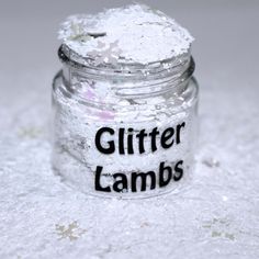 a jar filled with glitter lambs sitting on top of a white tablecloth covered floor