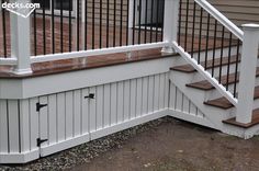 a wooden deck with white railing and handrails