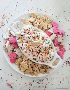 a white plate topped with lots of sprinkles next to a spoon filled with cake mix