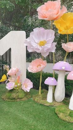 flowers are growing out of the ground in front of a number one sign and mushrooms