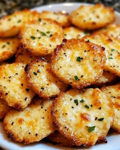 a white plate topped with cheesy crackers on top of a countertop