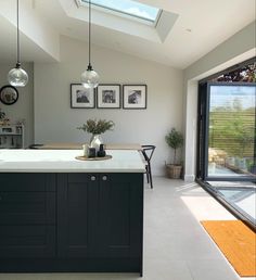 a kitchen with an island and skylight in it's center area, next to a dining room table