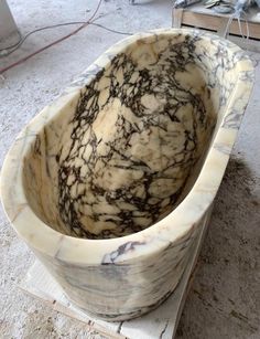 a marble bathtub sitting on top of a wooden block