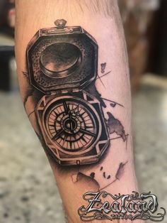 a man's leg with a tattoo on it and a compass in the middle