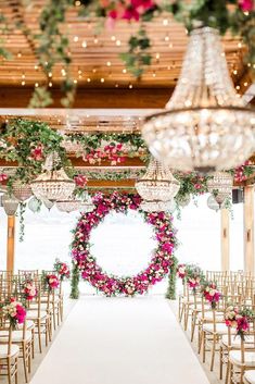 the aisle is decorated with pink flowers and greenery