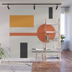 an orange and grey abstract painting on a wall in a living room with wooden floors