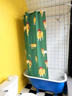 a bathroom with yellow walls and black and white checkered flooring, a blue claw foot bathtub next to a toilet