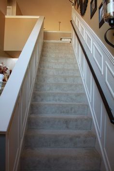 the stairs leading up to the second floor are white and have black framed pictures on them