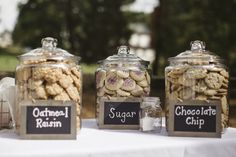 three jars filled with cookies sitting on top of a table