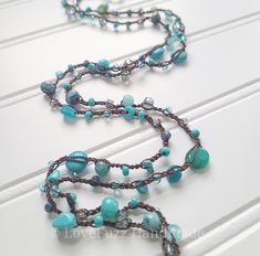 A stunning long beaded necklace made with a shimmering turquoise blue mix of czech glass and stone beads, all strung on a strong and waterproof nylon cord.  This can be worn many ways! A long necklace, doubled, or even tripled for a layered look. It can also be wrapped around your wrist as a bracelet.  Measures approx 50 inches and is finished with a nickel free sterling plated toggle clasp. Turquoise Beaded Necklaces With Gemstone Beads, Long Glass Necklace With Polished Beads, Blue Beaded Long Necklace With Adjustable Chain, Turquoise Long Hand-strung Beaded Necklaces, Blue Bead Bracelet, Blue Long Glass Necklace, Adjustable Blue Multi-strand Long Necklace, Turquoise Czech Glass Gemstone Beads, Blue Beaded Bracelets