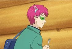 a man with pink hair and green glasses holding a fork in his hand while looking at something