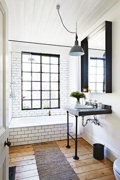 a bathroom with white walls and wooden floors