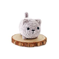 a small stuffed animal sitting on top of a wooden stump