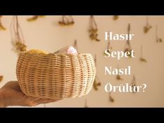 a person holding a basket with small objects hanging from it's sides and the words hasir sepet nasil orulir?