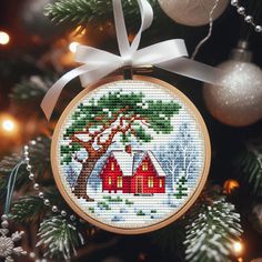 a cross stitch ornament hanging from a christmas tree