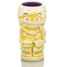 a yellow and white ceramic vase with an image of a person wearing a scarf on it