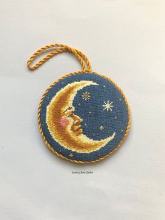 a needleed ornament with a crescent and stars on it's side