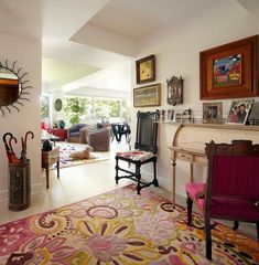 a living room filled with lots of furniture and art on the wall next to a fire place