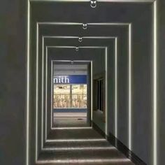 an empty hallway with white walls and lights