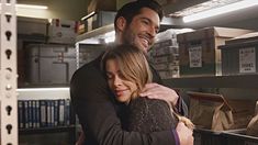 a man hugging a woman in front of shelves