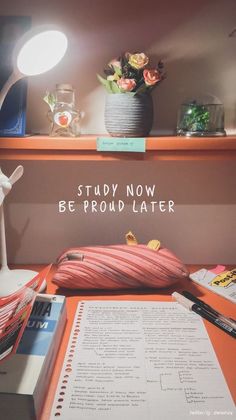 an open book sitting on top of a desk next to a lamp and some books