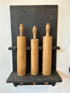 three wooden salt and pepper shakers on a shelf