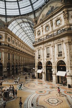 an indoor shopping mall with people walking around