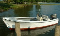 a small white boat tied to a wooden dock