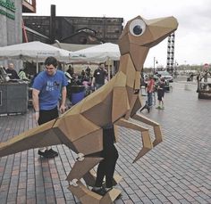 a man standing next to a cardboard animal