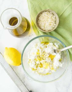 a bowl with cottage cheese and lemons next to a measuring cup