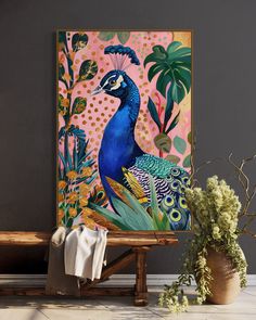 a peacock painting sitting on top of a wooden bench next to a potted plant