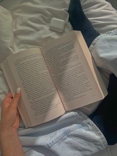 a person is reading a book in bed