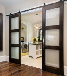 two doors open to reveal a kitchen and living room in the same house, one is white and the other is black