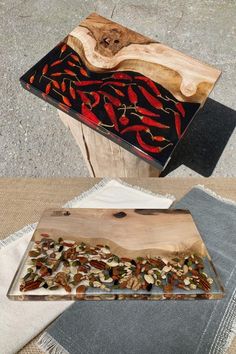 a wooden box sitting on top of a table next to a piece of wood with red and black designs