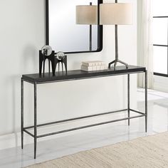 a black console table with two lamps and a mirror