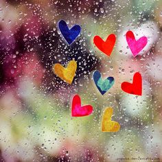 colorful hearts are seen through the window on a rainy day