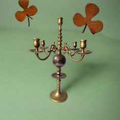 an old fashioned candelabra with four leafed clovers on the back