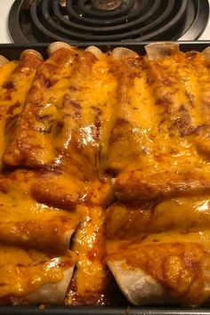 a casserole dish with cheese and meat in it on top of a stove