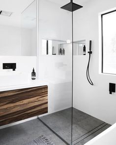 a bathroom with a shower, sink and mirror