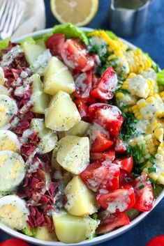 a bowl filled with potatoes, corn and tomatoes