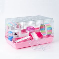 a pink toy hamster with its door open and some toys in the cage behind it