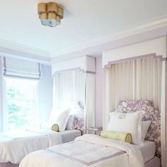 two beds in a room with white walls and curtains on the windows above them are instagrams