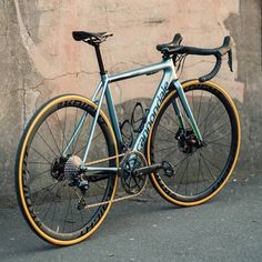 a blue and yellow bike parked in front of a stone wall