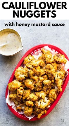 cauliflower nuggets with honey mustard sauce in a red bowl on a table