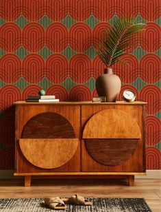 an art deco sideboard in front of a wallpapered background with circular shapes