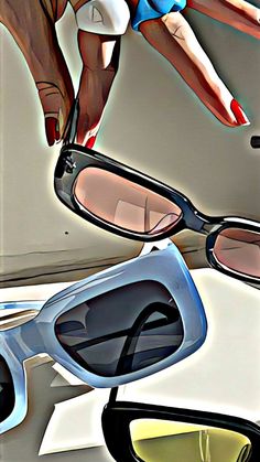 two pairs of sun glasses sitting on top of a table next to a woman's hand