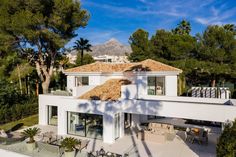 an aerial view of a house with trees and mountains in the backgrouds