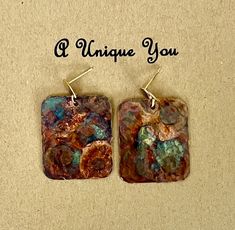 two square shaped earrings with words on the bottom and one saying, i unique you