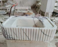 a white marble sink sitting on top of a counter in a room filled with rubble